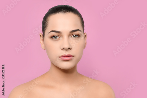 Portrait of young woman with beautiful face and natural makeup on color background