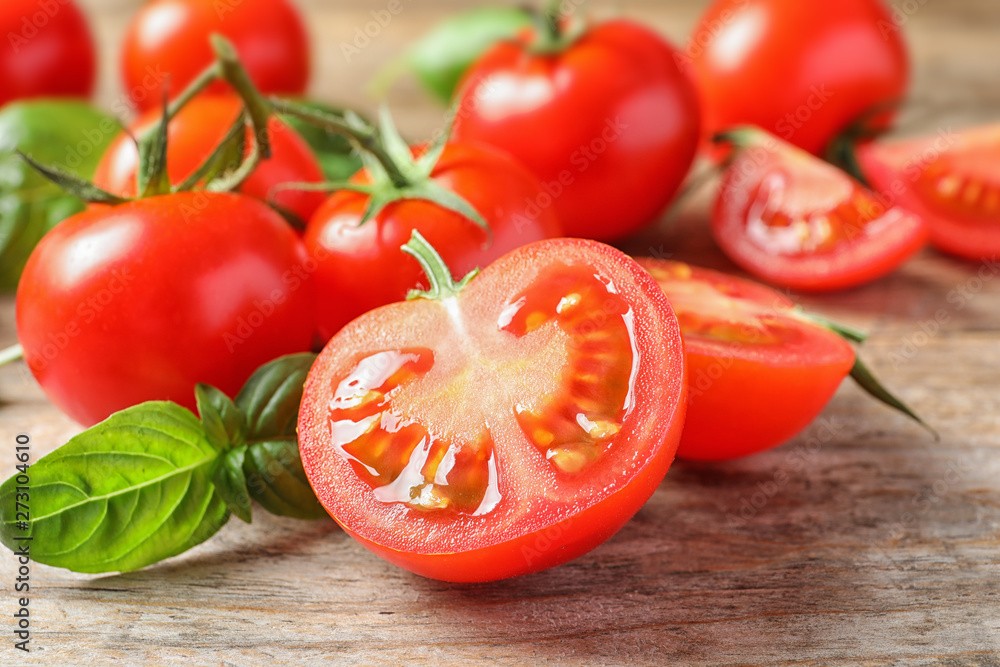 Fresh cherry tomatoes with basil on wooden background, closeup Fresh cherry tomatoes with basil on wooden background, closeup