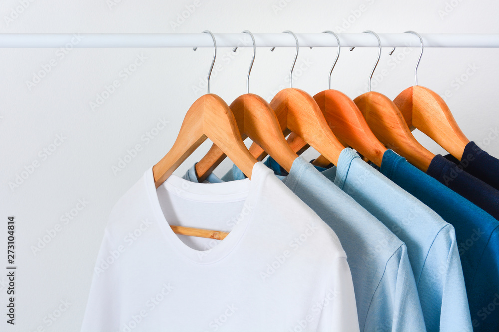 Udvalg krise Skæbne close up collection shade of blue tone color t-shirts hanging on wooden clothes  hanger in closet or clothing rack over white background with copy space  Photos | Adobe Stock