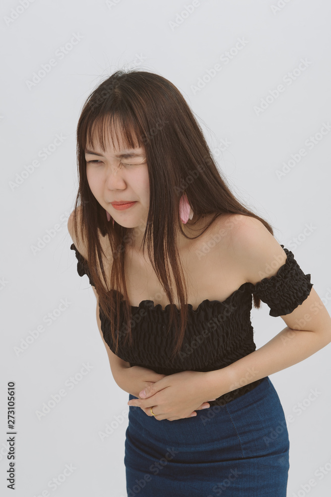 Asian woman with stomach ache, food poisoning, Menstrual pain; Female sick on grey background; Health care concept. Asian woman with stomach ache, food poisoning, Menstrual pain; Female sick on grey background; Health care concept.