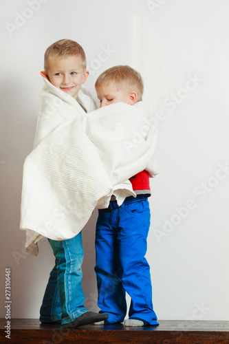 Two little boys siblings playing with towels