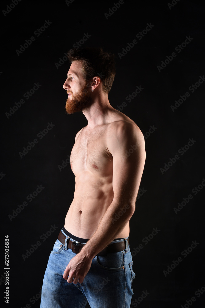 Retrato del hombre sin camisa y con el fondo negro.