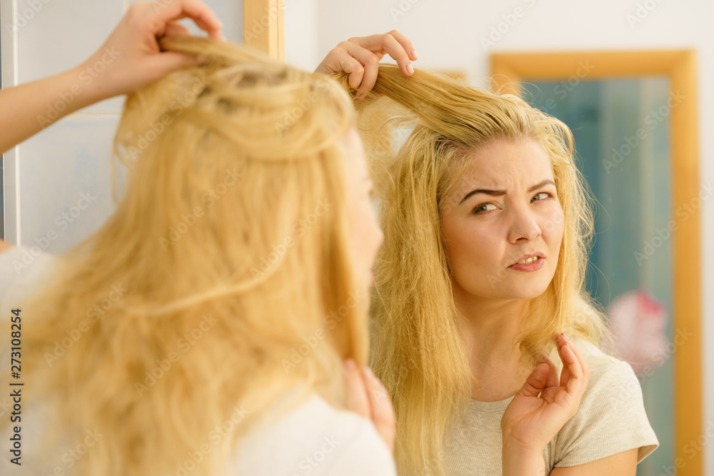 Fototapeta premium Female having problem with blonde hair