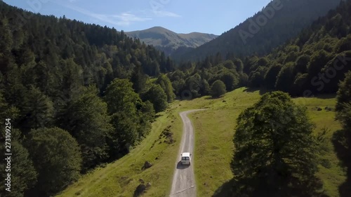 Drone shot. A van is drive in a small road in the mountain in the french pyrénées. photo