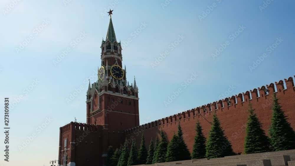 Clock on Spasskaya Tower of the Kremlin against the blue sky on a sunny summer day. Red Square in Moscow, the capital of Russia. City center, tourist place Clock on Spasskaya Tower of the Kremlin against the blue sky on a sunny summer day. Red Square in Moscow, the capital of Russia. City center, tourist place
