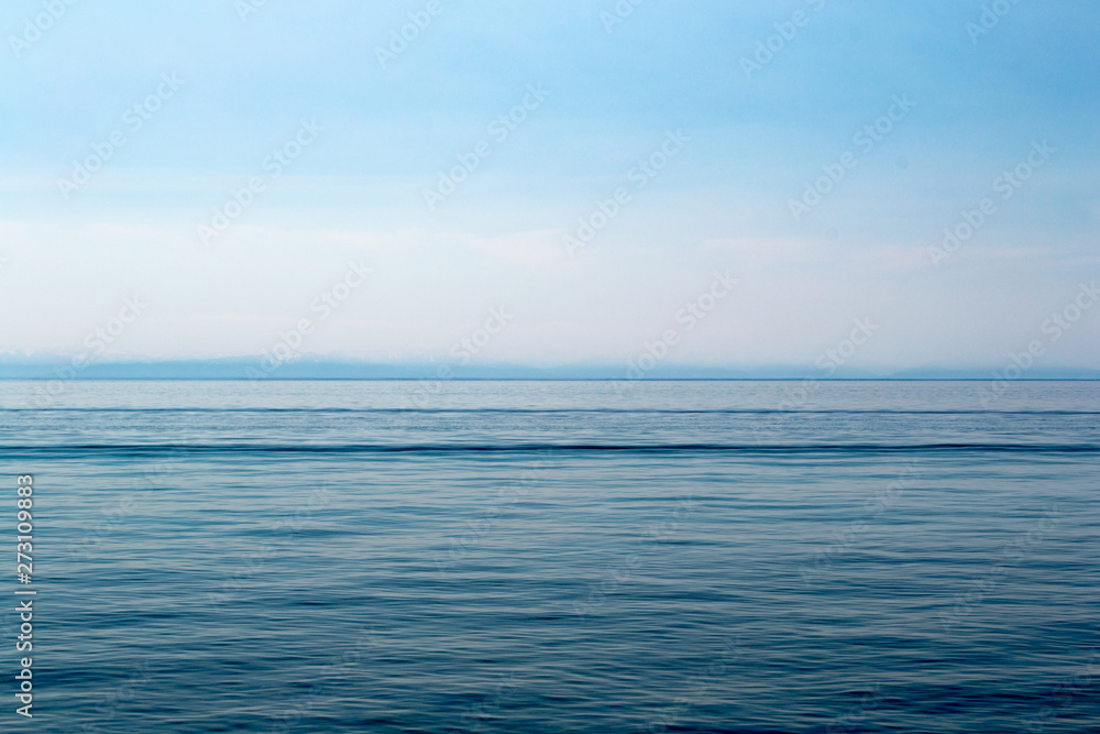 Lake Baikal on a sunny day. Clear blue sky and water. Free space for text. Background for design, screen saver