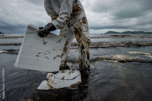 volunteers cleaning up a beach from a oil slick on Ao Phrao beach on Samed Island, rayong, Thailand.  photo