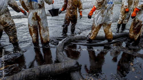 volunteers cleaning up a beach from a oil slick on Ao Phrao beach on Samed Island, rayong, Thailand. 