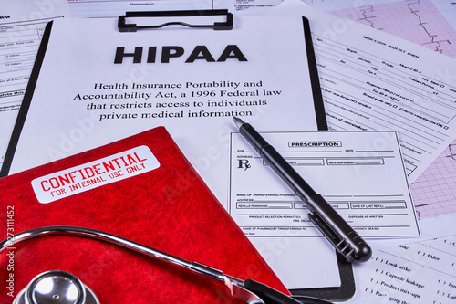 Health Insurance Portability and accountability act HIPAA, red folder with inscription confidential, prescription pen and stethoscope on the medical documents background