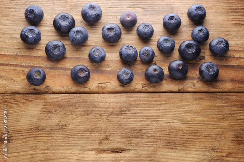Blueberry on vintage wooden background.