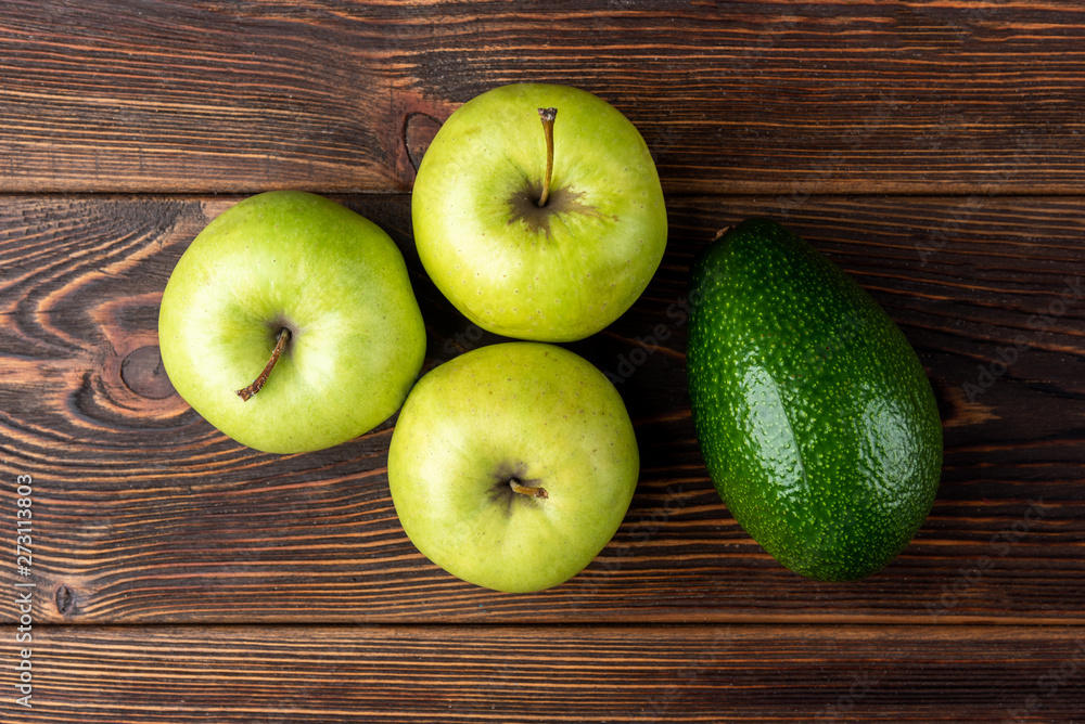 Avocado and green apple on dark wooden background. Avocado and green apple on dark wooden background.