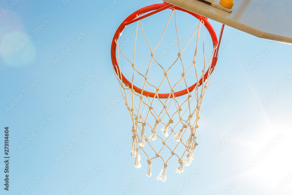 Game sports, competitions. Team sports, outdoor leisure, active recreation, entertainment. Basketball hoop with net against blue sky in a schoolyard outdoors