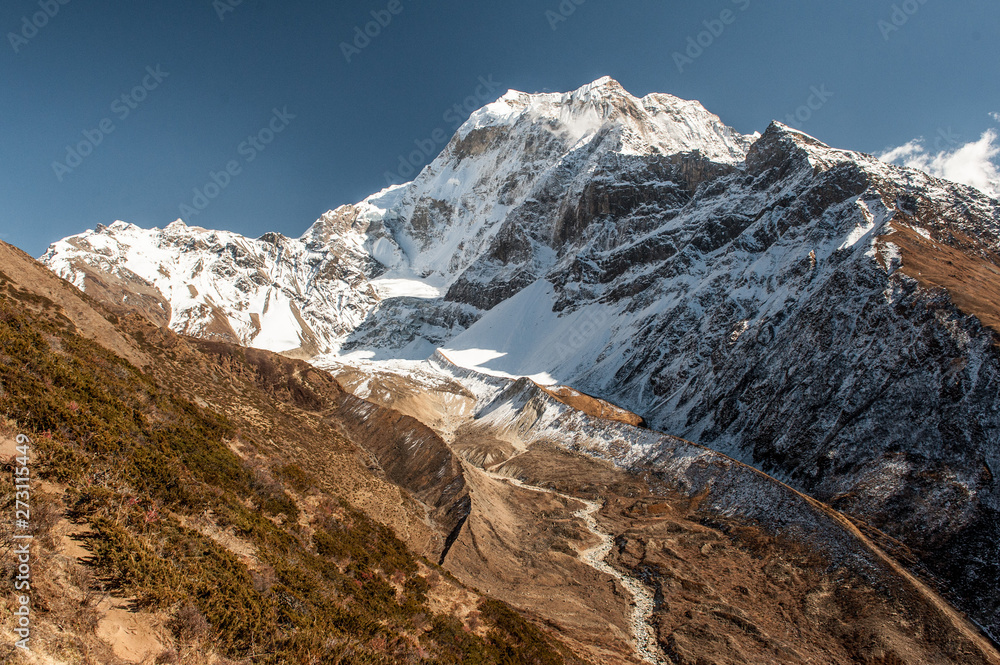 Huge valley with river on Manaslu circuit with view of snow covered Mount Manaslu 8 156 meters. Himalayas, sunny day at Manaslu Glacier in Gorkha District in northern-central Nepal. 