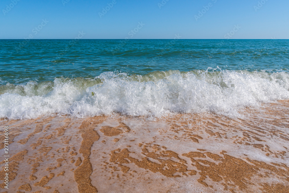 Empty summer beach with golden sand and azure water