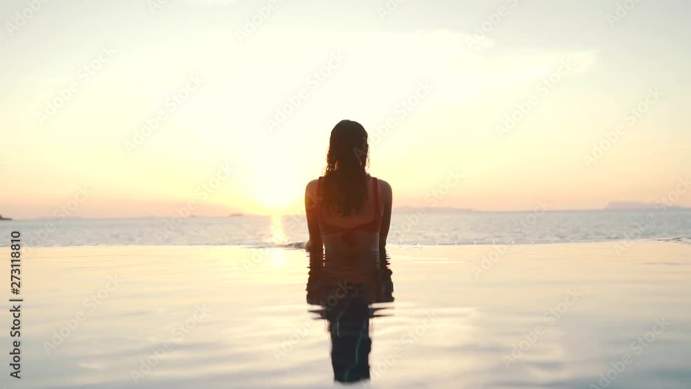 girl in the pool on the background of the ocean at sunset girl in the pool on the background of the ocean at sunset