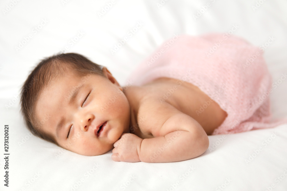 Adorable asian newborn baby in pink wrap sleeping on white blanket background. Adorable asian newborn baby in pink wrap sleeping on white blanket background.