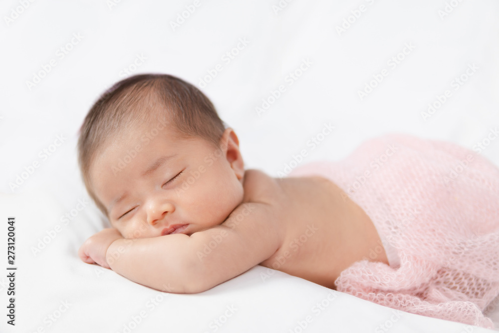 Adorable asian newborn baby in pink wrap sleeping on white blanket background. Adorable asian newborn baby in pink wrap sleeping on white blanket background.