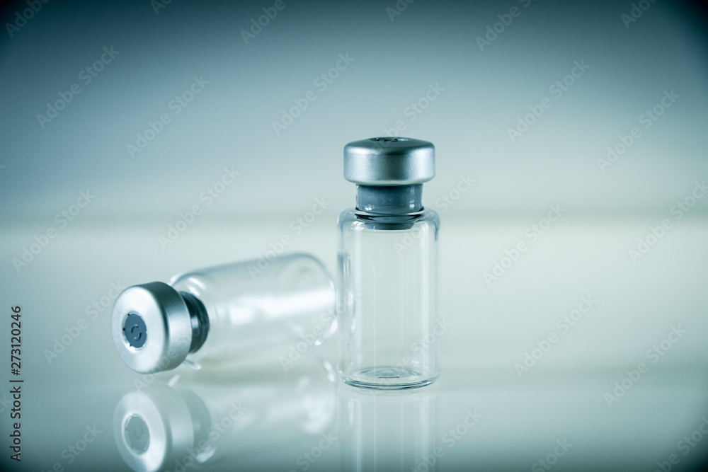 two vaccine bottles on grey background two vaccine bottles on grey background