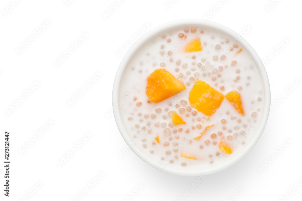 A bowl of sweet sago cream with mango and coconut milk on white background.Top view. A bowl of sweet sago cream with mango and coconut milk on white background.Top view.