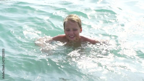Wallpaper Mural Cute white kid has fun in water of warm blue wavy sea during summer beach holidays. Slow motion full hd video footage. Torontodigital.ca