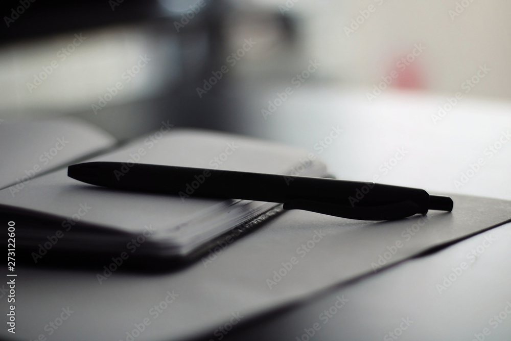 Fototapeta premium Notepad with black pen on top.