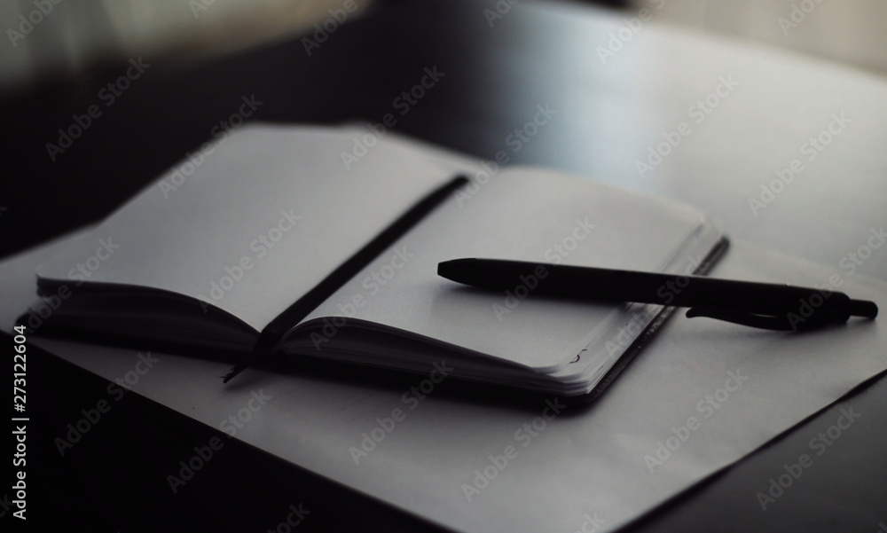 Fototapeta premium Notepad with a black pen on top.
