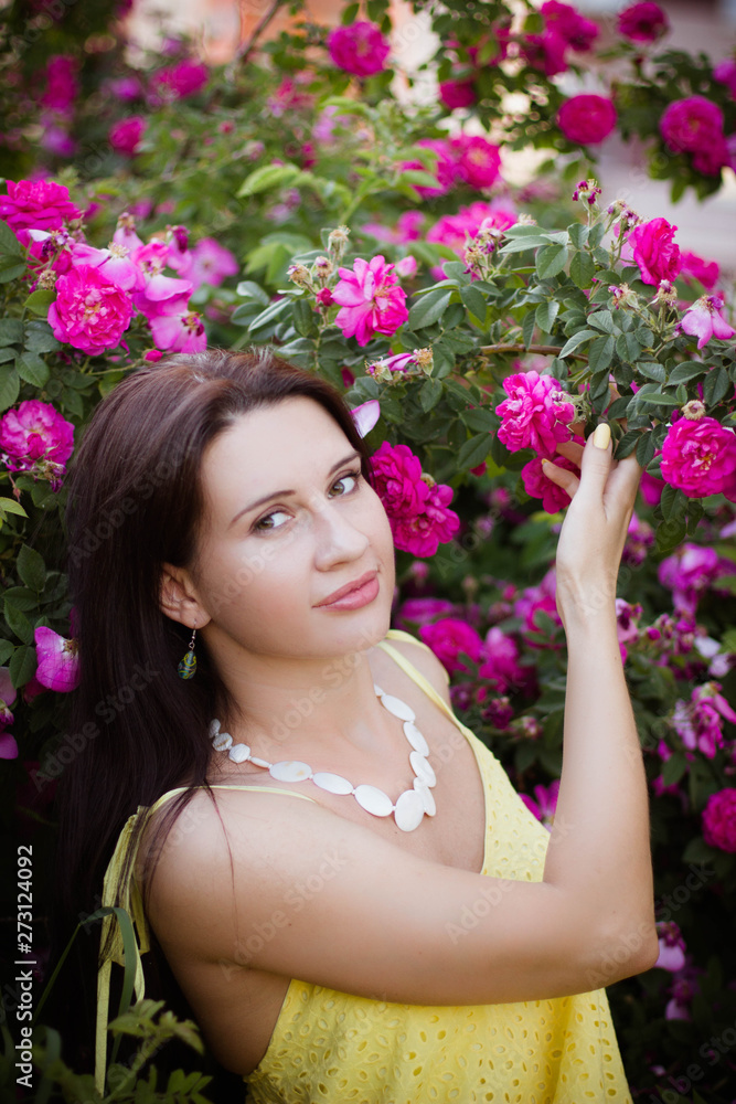 Fototapeta premium portrait of a young girl in pink rose hips