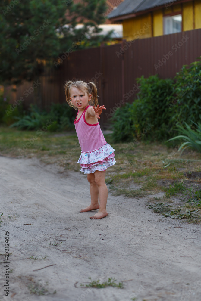 A girl playing with a stick outside in the country. Concept of a happy childhood out of town A girl playing with a stick outside in the country. Concept of a happy childhood out of town