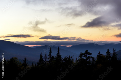Wooded mountains and pink clouds on the peaks at sunset. White Mountain National Park. USA. New Hamshire.