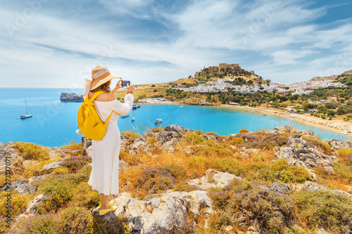 Konstfotografi Young woman traveler taking photo of her smartphone scenic landscape of a famous