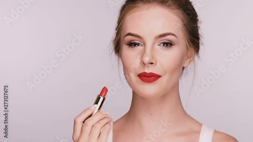 close-up of pretty girl applying red lipstick photo