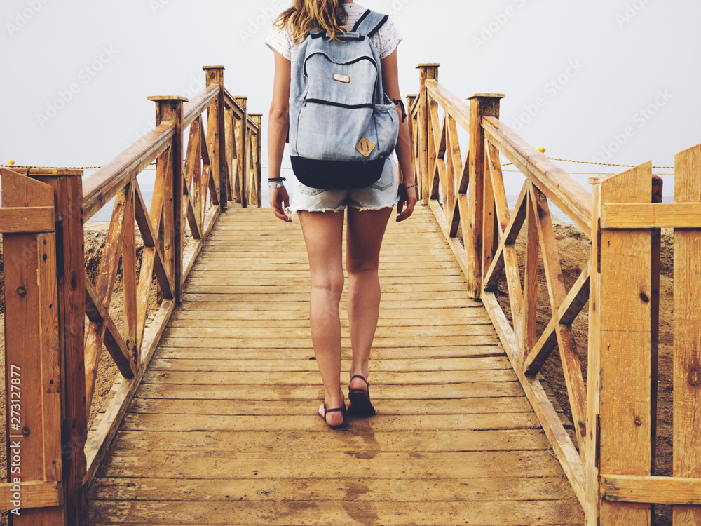 Single woman near the ocean / sea on a wooden pier. Single woman near the ocean / sea on a wooden pier.