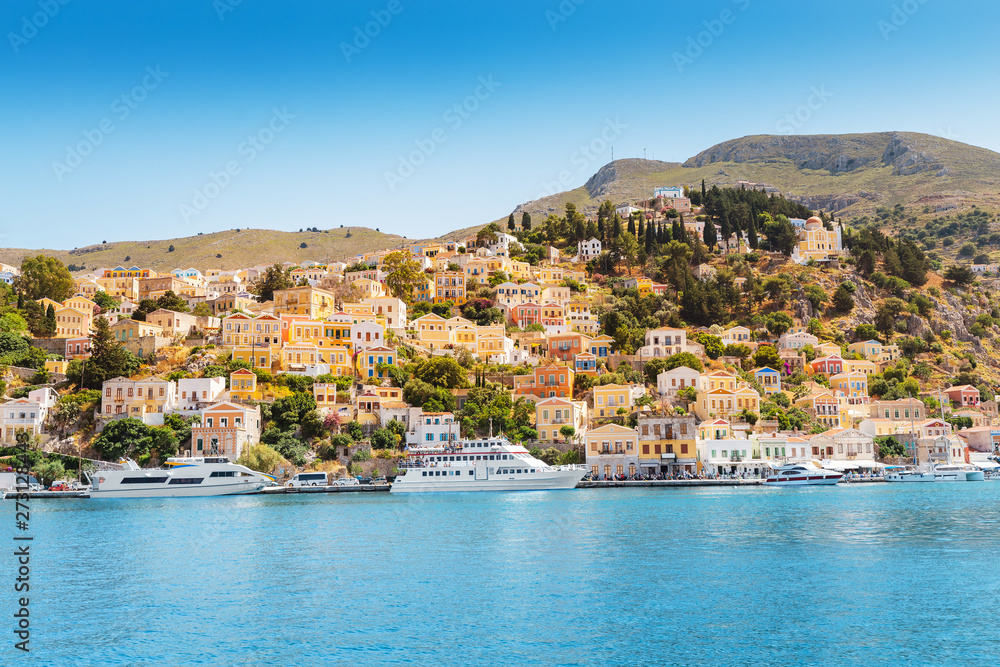 Colorful island Symi - popular tourist attraction with fishing boats in a harbor