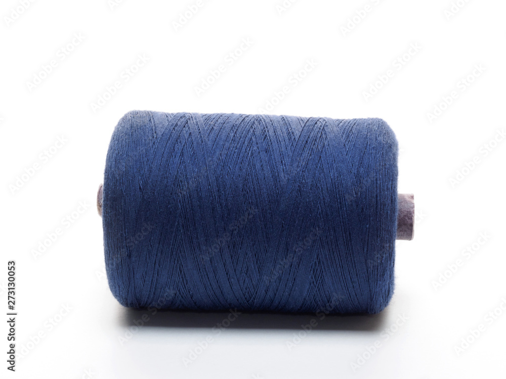 Blue spool of thread in a horizontal position on a white background Blue spool of thread in a horizontal position on a white background