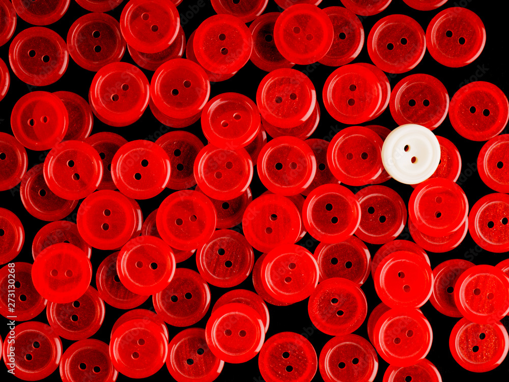 Many red buttons and one white on a black background Many red buttons and one white on a black background