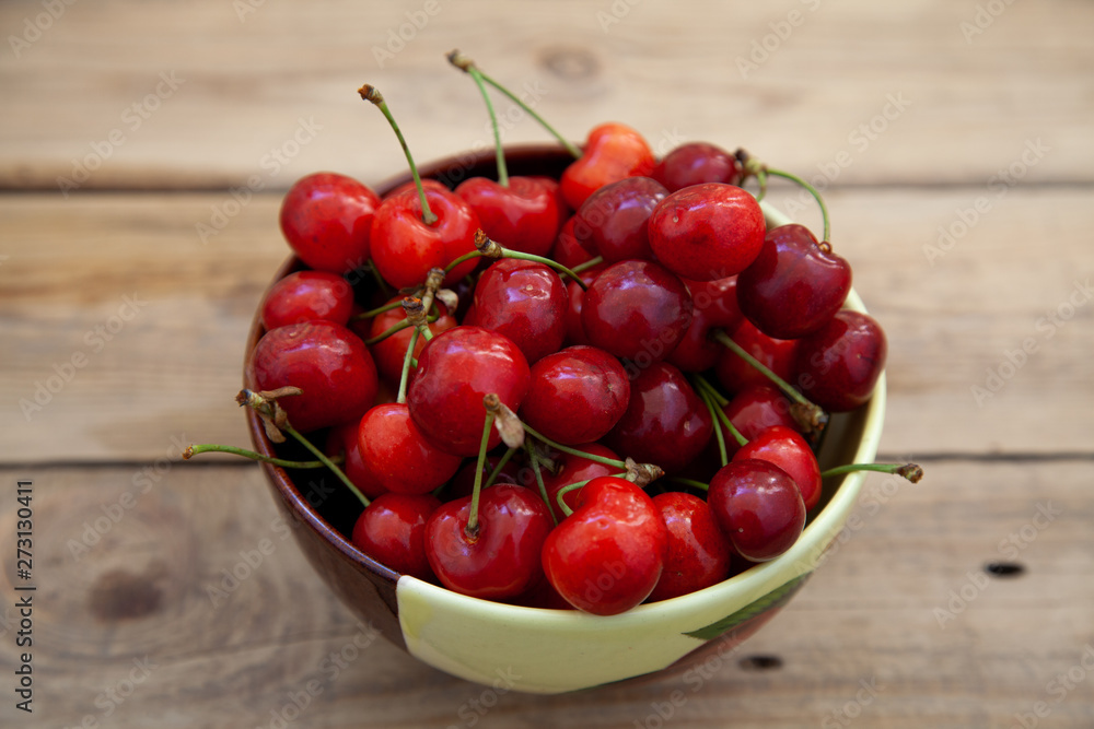 ripe red sweet cherry in a bowl on a wooden table ripe red sweet cherry in a bowl on a wooden table