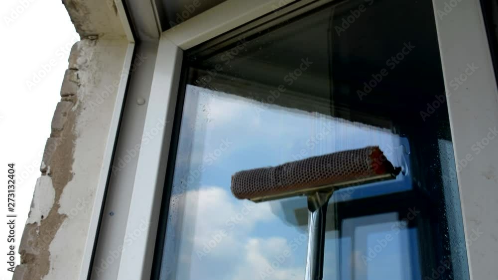 washes a window in the office building on a working day washes a window in the office building on a working day