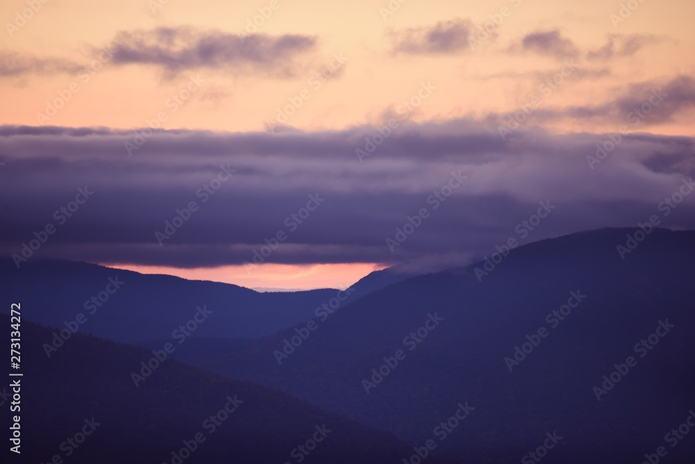 Wooded mountains and pink clouds on the peaks at sunset. White Mountain National Park. USA. New Hamshire. Wooded mountains and pink clouds on the peaks at sunset. White Mountain National Park. USA. New Hamshire.