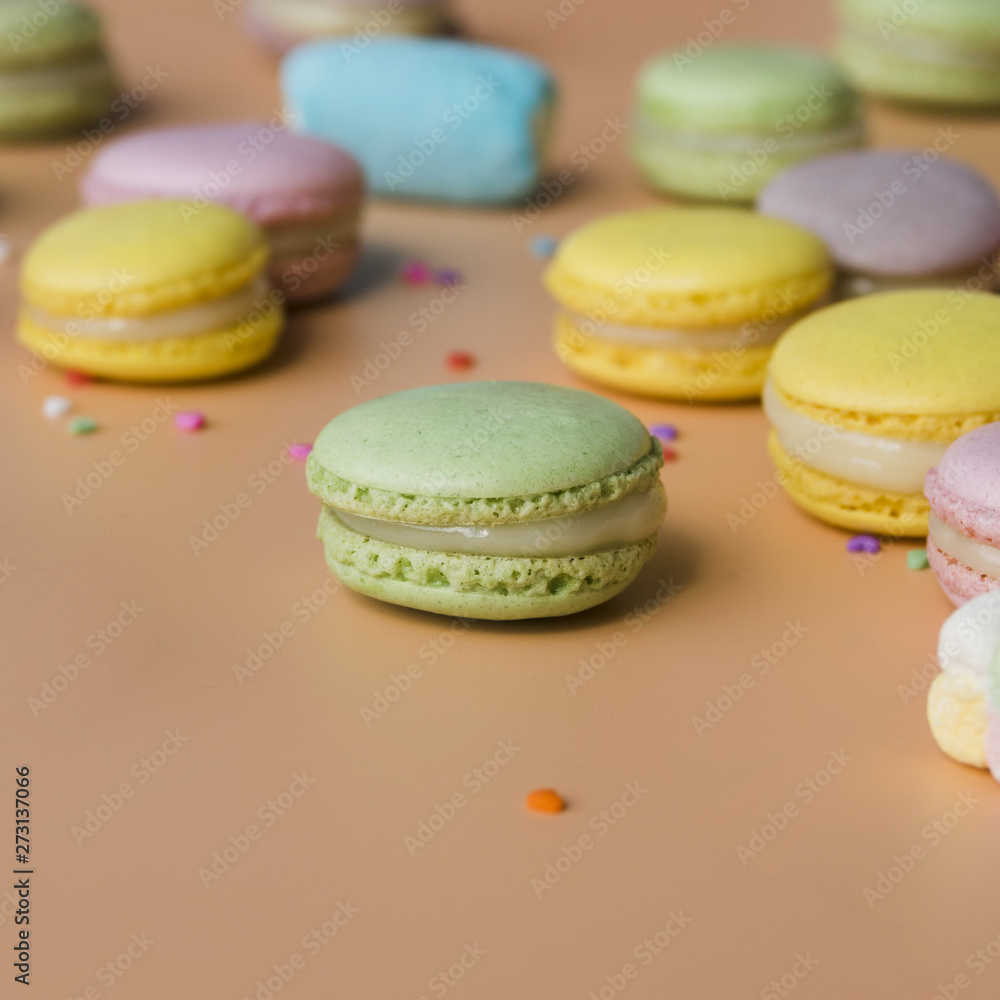 Green; yellow; pink; and blue macaroons on colored background Green; yellow; pink; and blue macaroons on colored background