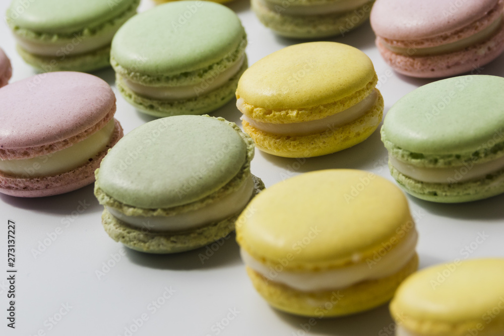 Row of fresh tasty macaroons on white backdrop Row of fresh tasty macaroons on white backdrop