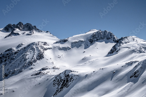 Single ski touring track leading up alpine mountain slope