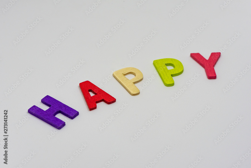 The HAPPY text from colorful wooden letters is on white background, learning alphabet, Sensitive focus. The HAPPY text from colorful wooden letters is on white background, learning alphabet, Sensitive focus.