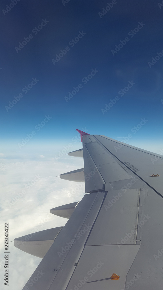 An airplane window view of wing and flaps An airplane window view of wing and flaps