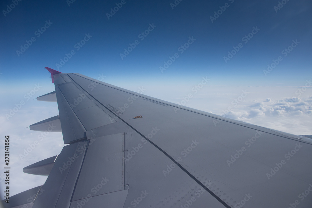 An airplane window view of wing and flaps An airplane window view of wing and flaps