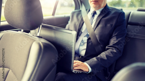 transport, business trip, technology and people concept - senior businessman with laptop computer driving on car back seat © Syda Productions