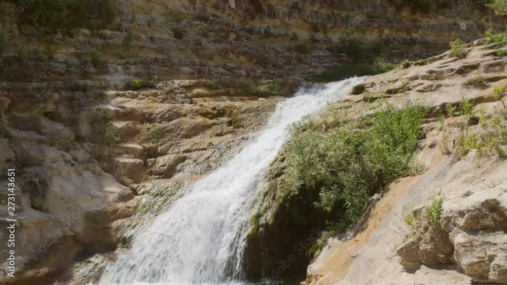 A PANNING SHOT of a beautiful waterfall in a canyon. A PANNING SHOT of a beautiful waterfall in a canyon.