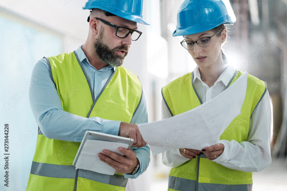 Fototapeta premium Engineers in hardhats have conversation