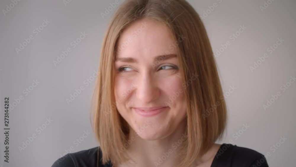 Closeup portrait of young cute caucasian girl smiling happily looking at camera indoors in the empty room Closeup portrait of young cute caucasian girl smiling happily looking at camera indoors in the empty room