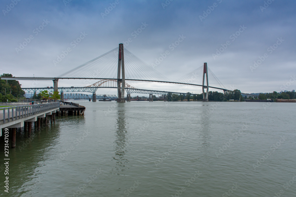 The Patullo bridge in New Westminster, British Columbia, Canada from the Quay looking to the Fraser River and skytrain bridge, Surrey, and blue sky.