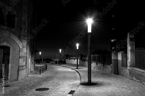 Row of streetlights in a curved and cobbled Street